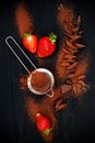 Ingredients for making chocolate brownies. Strawberries, chopped chocolate with cocoa over black wooden background, top view. Royalty Free Stock Photo