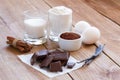 Ingredients for making chocolate chip cookies on a wooden background