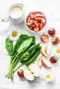 Ingredients for making coconut probiotic yogurt, spinach, apple, strawberry detox smoothie on a light background, top view.