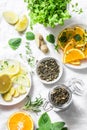 Ingredients for making cold aromatic green tea - dry green tea, lemon, orange, ginger, mint, rosemary on a light background, top v Royalty Free Stock Photo
