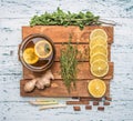 Ingredients for making fragrant tea on a wooden tray, ginger, lemon, mint and cinnamon on a white rustic background,