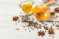 Ingredients for making Golden milk with turmeric. Turmeric powder, linseed oil, black pepper and spices. Close-up on a light