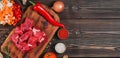 Ingredients for making goulash or stew, stew or gyuvech: top view of raw beef meat, herbs, spices, paprika, vegetables on a dark