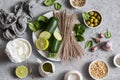 Ingredients for making green soba bowl - zucchini, spinach, soba, yogurt on grey background, top view. Healthy vegetarian food con
