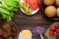 Ingredients for making hamburgers (bread rolls, tomatoes, cucumbers, onion rings, lettuce, pork chops, cheese) Royalty Free Stock Photo