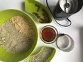 Ingredients for making homemade halva. Roasted peanuts and seeds in containers. Nearby is a coffee grinder, honey and chopped