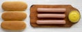 Ingredients for making hot dogs: sausages, hot-dog buns and mustard on white wooden background, top view. Flat lay, overhead, from Royalty Free Stock Photo