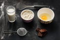 Ingredients for making muffins on a black surface sprinkled with flour Royalty Free Stock Photo