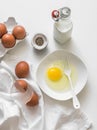 Ingredients for making an omelet - eggs, milk, pepper on a light background, top view