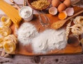 Ingredients for making pasta, flour, on a vintage wooden cutting board Royalty Free Stock Photo