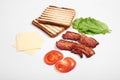 Ingredients for making sandwich. fresh vegetables, tomatoes, bread, becon. Isolated on white background, top view, copy