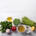 Ingredients for middle eastern tabbouleh salad. Bulgur, fresh young green asparagus, green peas, tomato, red onion, herbs, lemon,