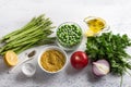 Ingredients for a middle eastern tabbouleh salad. Bulgur, fresh young green asparagus, green peas, tomato, red onion, herbs, lemon