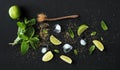 Ingredients for mojito. Fresh mint, limes, ice, sugar over black backdrop Royalty Free Stock Photo