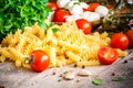Ingredients for pasta: organic cherry tomatoes, mozzarella, fresh basil, fusilli, garlic and olive oil Royalty Free Stock Photo