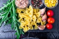 Ingredients for pasta salad in slate plate with tomatoes cherry, tuna, corn and arugula. Top view. Italian food. Royalty Free Stock Photo