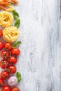ingredients pasta tomatoes basil frame on white wooden background Royalty Free Stock Photo