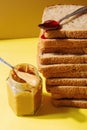 Ingredients for peanut butter and jelly sandwiches. Spoon with strawberry jam on pile of toast bread Royalty Free Stock Photo