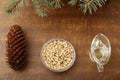 Ingredients for pesto: olive oil, pine nuts, cones, brunches on a wooden broun background