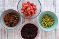 Ingredients for a poke in a bowl. Tomatoes, black rice, tuna or salmon and soybeans
