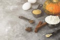 Ingredients for pumpkin pie - flour, pumpkins, eggs, cane sugar, various spices (nutmeg, ginger, cinnamon, anise) on a gray Royalty Free Stock Photo