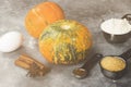 Ingredients for pumpkin pie - flour, pumpkins, eggs, cane sugar, various spices (nutmeg, ginger, cinnamon, anise) on a gray Royalty Free Stock Photo