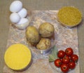 Quick cooking of the second course for lunch: eggs, potatoes, bulgur, cherry tomatoes, bay leaf, corn grits Royalty Free Stock Photo