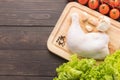 Ingredients and raw chicken leg on cutting board on wooden background Royalty Free Stock Photo