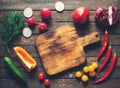 Ingredients for salad around cutting board. Fresh vegetables and herbs. Cooking Royalty Free Stock Photo