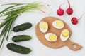 Ingredients for salad: boiled eggs, radishes, cucumbers and green onions are located on a white background.