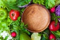 Ingredients for salad and a wooden empty bowl