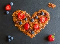 Ingredients in shape of heart to cook a breakfast. Blueberries, strawberries and granola made from oat flakes, dried fruits, nuts Royalty Free Stock Photo