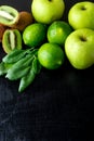 Ingredients for smoothie. Green fruits on black wooden background. Apple, lime, spinach, kiwi. Detox. Healthy food. Top view. Copy Royalty Free Stock Photo