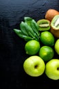 Ingredients for smoothie. Green fruits on black wooden background. Apple, lime, spinach, kiwi. Detox. Healthy food. Top view. Copy Royalty Free Stock Photo