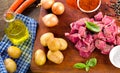 Ingredients for stew or goulash on old cutting board.