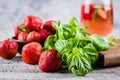 Ingredients for Summer Drink Strawberry Basil Lemonade on concrete table background. Close-up