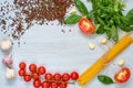 Ingredients for tasty pasta: raw cherry tomatoes, basil, garlic, pepper on the gray concrete kitchen table with space for text Royalty Free Stock Photo