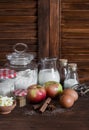 Ingredients and tools for baking - flour, eggs, butter, apples, cinnamon on a brown rustic wooden surface. Royalty Free Stock Photo