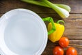 Ingredients for vegetable soup are on the wooden table next to the empty green pot. Royalty Free Stock Photo