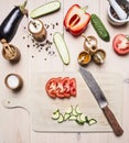 Ingredients for vegetarian salad, cucumbers, eggplant, red bell pepper, tomatoes, spices and herbs, lies next to cutting board a