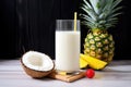 ingredients of virgin pina colada pineapple, coconut milk styled around a glass