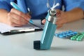 Inhaler against nurse sitting at the table and writing Royalty Free Stock Photo