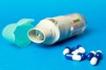 inhaler and pills against asthma on blue background. COPD