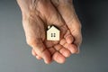 Inheritance concept. Elderly woman hands holds a little toy house. Royalty Free Stock Photo