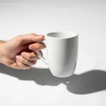Inimalism, with the focus on the hand\'s gentle grip and the mug\'s Royalty Free Stock Photo