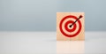 Initiation for planning to reach target. Darts target aim icon on wooden cubes with grey background. Focus on goal and achieve Royalty Free Stock Photo