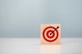Initiation for planning to reach target. Darts target aim icon on wooden cubes with grey background. Focus on goal and achieve Royalty Free Stock Photo