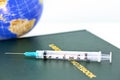 Injection needle, Lab Notebook, and world image reflect global medicine Royalty Free Stock Photo