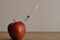 An injection needle stuck into an apple