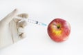 Injection into red apple - Genetically modified fruit and syringe with red chemical. GMO food. Laboratory research and fruit Royalty Free Stock Photo